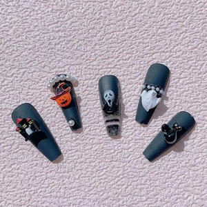 Detail of Halloween nail art with 3D resin ghost, pumpkin, and black cat decorations