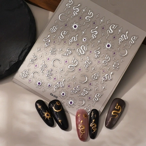 Detailed silver snake and moon nail stickers with metallic embossed effects on a dark base