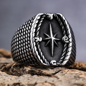 Macro shot of vintage silver Viking compass ring on a natural wood background