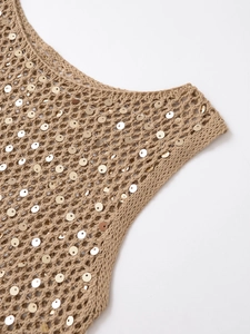 Détail de gilet en maille ajourée beige avec paillettes dorées et texture tissée