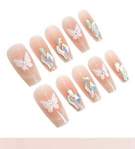 Detailed macro view of coffin-shaped press-on nails with 3D butterfly and crystal rhinestones
