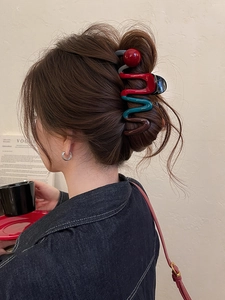Detail of a large wavy claw clip with wine red and emerald green color-blocking design