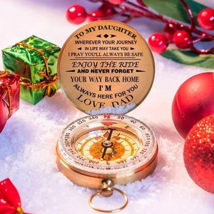Detailed view of engraved compass lid with sentimental message for daughter on a festive background