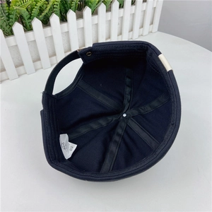 Internal details of black cotton brimless cap with adjustable metal buckle and strap