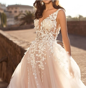 Detailed embroidery on a sleeveless deep V-neck bridal gown with 3D floral lace and tulle