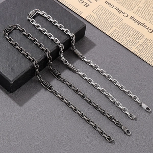 Close-up of vintage biker necklaces in silver and gunmetal with spring ring clasps