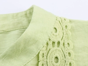 Detail of light green blouse featuring textured fabric and intricate lace patchwork on shoulder