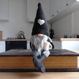 Nordic knitted gnome decoration with black heart hat and coffee cup on books