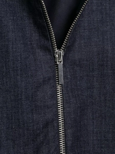 Macro shot of silver metal zipper and premium twill denim texture of the bomber jacket