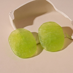 Detail view of green translucent acrylic earring charms with elegant textured finish