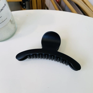 Detail view of the serrated teeth and matte black finish of a medium-sized shark hair clip