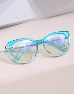 Detailed side view of cat-eye glasses with transparent blue frame and gold metal hinges