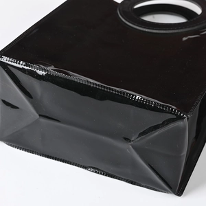 Minimalist black glossy PVC tote bag featuring a unique creative round cutout handle