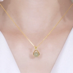 Elegant Hetian jade lucky bag pendant necklace in gold setting worn by a model