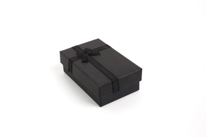 Close-up of a premium black jewelry gift box with a silk bow for rings and necklaces