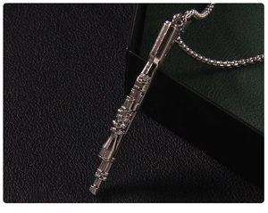 Close-up of a silver clarinet pendant displayed in a premium black textured gift box