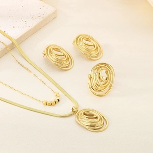 Macro shot of gold plated jewelry set including necklace, earrings and ring on stone base