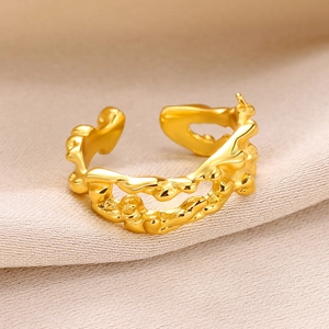 Detailed view of a gold-plated irregular lava style ring on elegant beige silk fabric