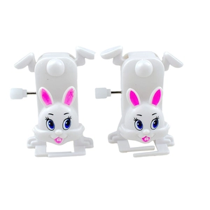 Close-up of two white wind-up bunny toys with blue eyes and pink ears made of plastic