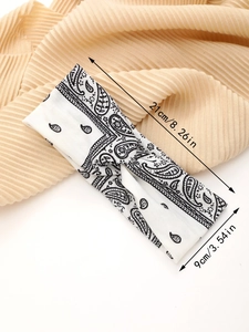 Detail showing the 21cm by 9cm dimensions of the paisley printed elastic headband
