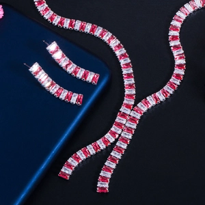 Dettaglio macro del set di collana e orecchini da sposa in zircone rosso e bianco