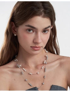 Close-up of elegant French vintage layered pearl necklace and matching stud earrings on model