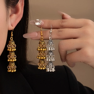 Detailed view of bohemian triple-tier Jhumka earrings with intricate hollow carvings