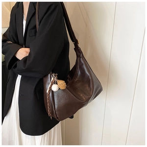 Detail of dark brown hobo bag with a stylish baseball and glove charm decoration