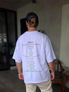 Close-up of oversize white cotton T-shirt back with black religious letter printing