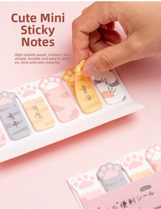 Close-up of cute cat paw sticky notes in pink and yellow colors for page marking