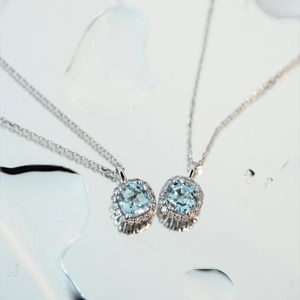Macro shot of square aquamarine pendant necklace with halo diamond setting and water drops