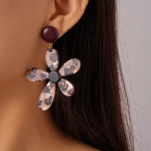 Detailed close-up of leopard print floral drop earrings on model for a retro vintage style