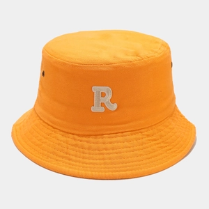Close-up of orange cotton bucket hat with embroidered letter R and ventilation eyelets