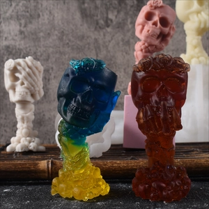 Detail of rose skull candle mold crafts in translucent blue, red, pink, and ivory finishes