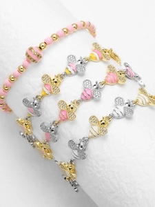 Detailed shot of bee charms with enamel finish and zircons on gold plated chain bracelets