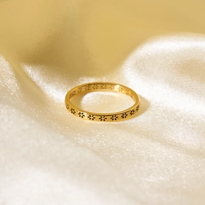 Minimalist gold stainless steel ring with floral engraving on champagne silk background