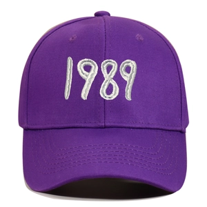Detailed close-up of 1989 embroidery on a purple cotton canvas baseball cap
