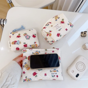 Detailed set of three quilted storage bags with vintage floral girl print and logo