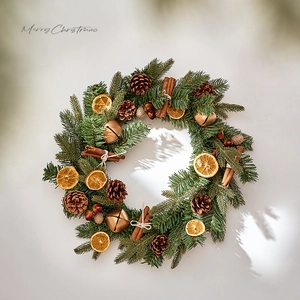 Christmas wreath with dried orange slices, pine cones, cinnamon sticks and bells