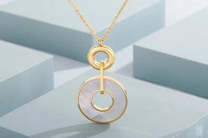 Macro detail of gold-plated stainless steel necklace pendant with white shell inlay