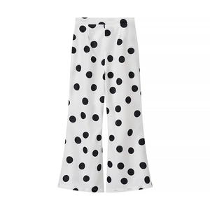Détail du pantalon large blanc à pois noirs confectionné dans un tissu respirant