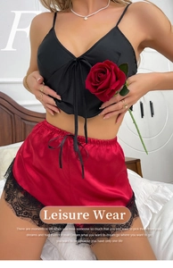 Detail of red satin shorts with delicate black eyelash lace trim and silky texture