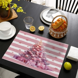 Detail of pink Christmas placemat with festive tree and gifts on a black table
