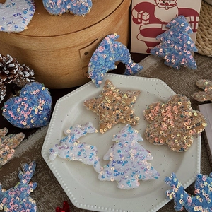 Sparkly Christmas sequins decorations featuring tree, star and heart shapes in warm setting