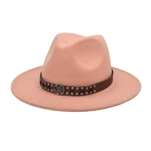 Detail of pink wool fedora hat featuring a brown leather band with metal studs