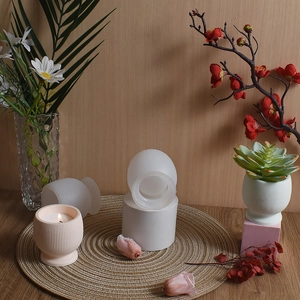 Detailed view of striped candle resin mold and a finished pale pink jar on a straw mat