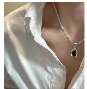 Detail of a minimalist silver S925 necklace featuring a rectangular black onyx pendant