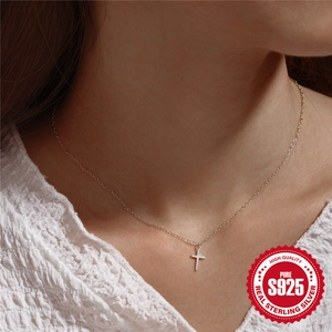 Minimalist 925 sterling silver cross pendant necklace on female model close-up view