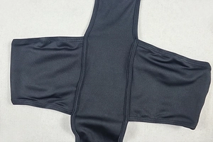 Detailed close-up of reinforced stitching on black elastic fabric bodysuit
