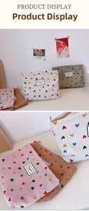 Detailed close-up of corduroy makeup bag with heart embroidery and vintage zipper